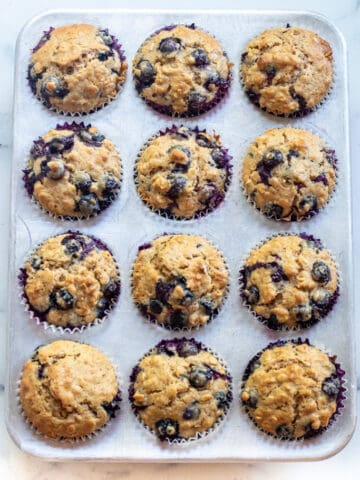 a muffin tin of blueberry muffins.