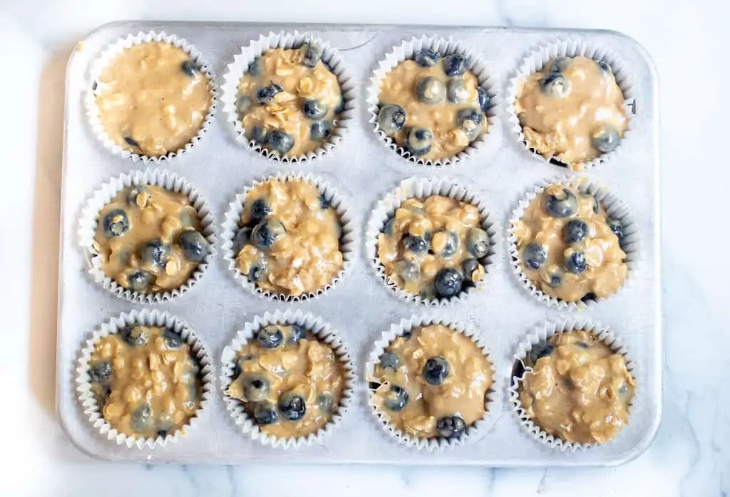 raw muffin dough in a muffin tin.