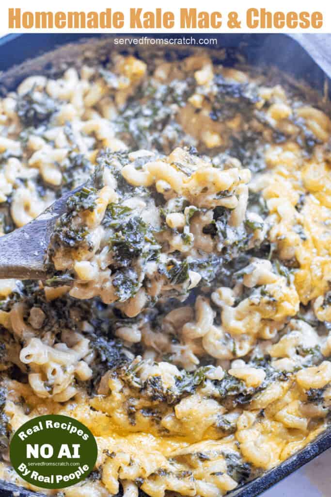 a cast iron skillet with mac n cheese with kale and a wooden spoon with Pinterest pin text with NO AI sticker.