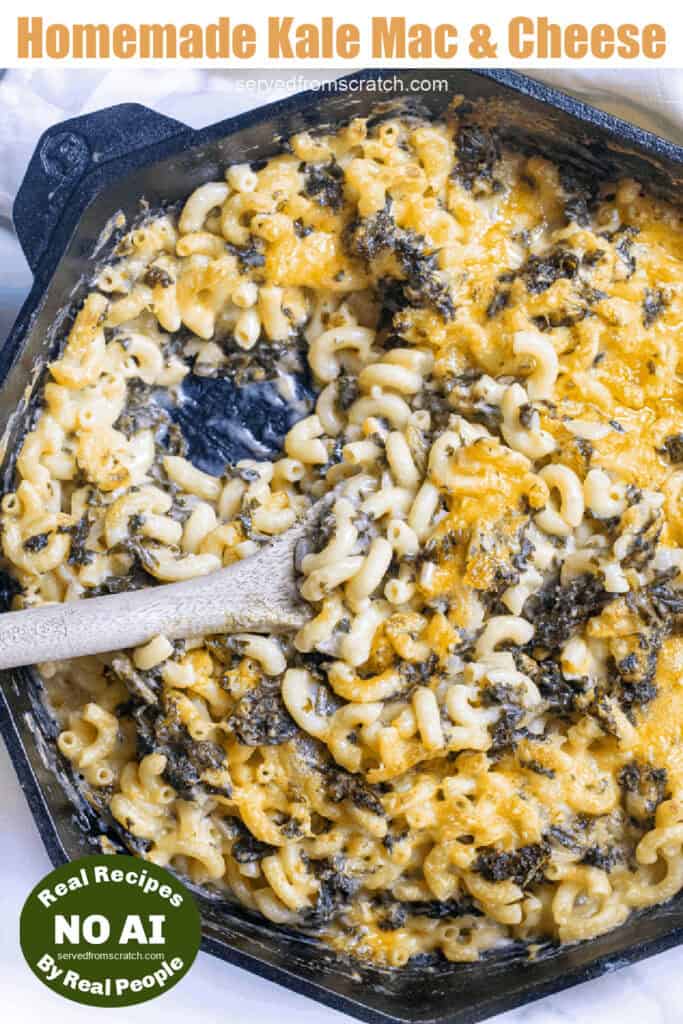 a cast iron skillet with mac n cheese with kale and a wooden spoon with Pinterest pin text with NO AI sticker.