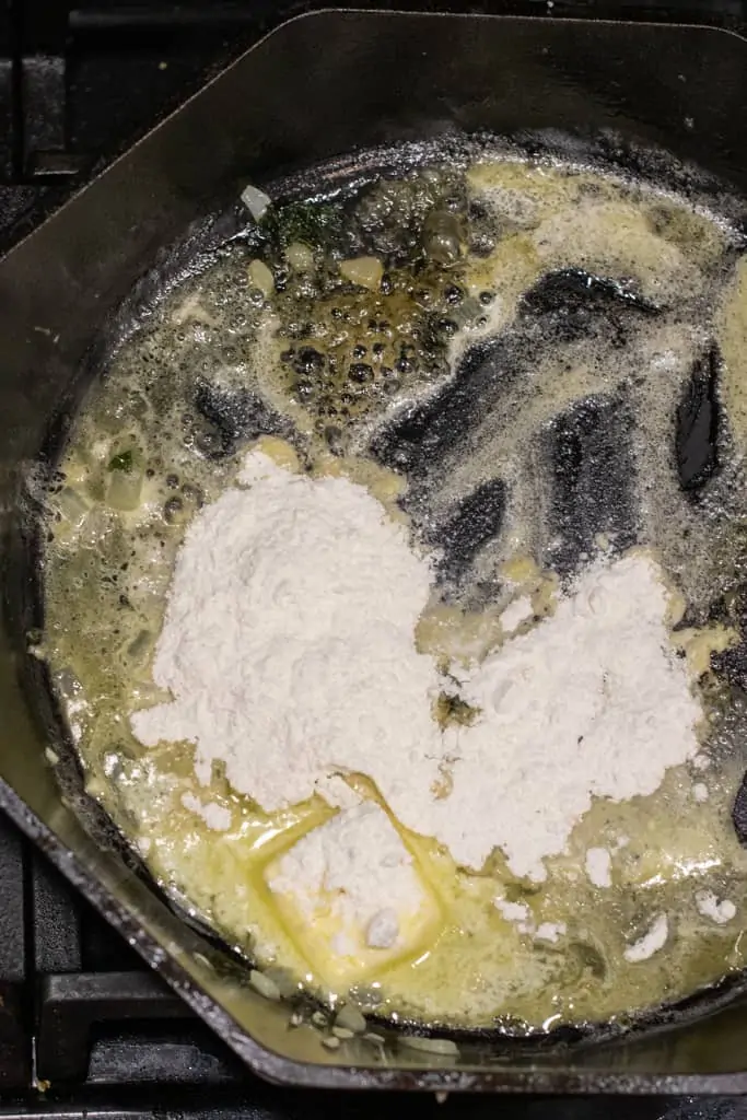 a roux being made in a cast iron skillet.