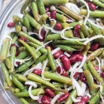 a bowl of fresh green beans, kidney beans, and onions.