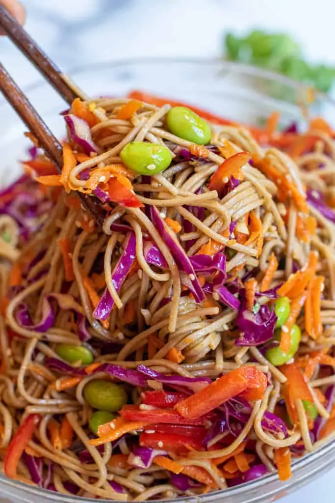 chopsticks holding up a soba noodle salad.