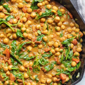 a cast iron of chickpea curry with spinach.