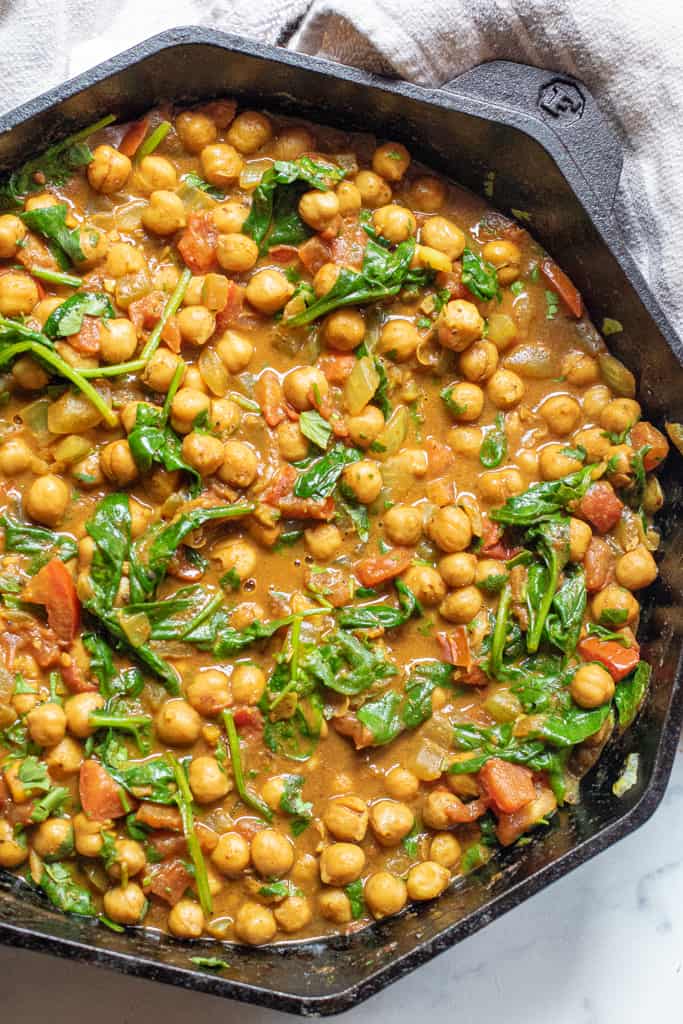 a cast iron of chickpea curry with spinach.