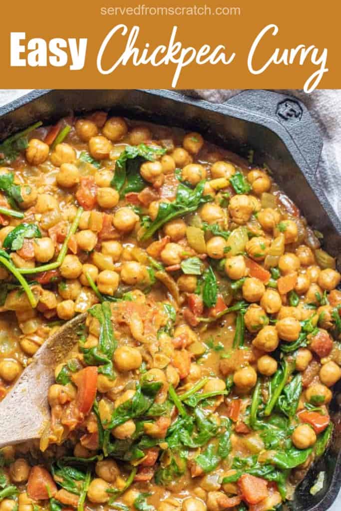 a cast iron of chickpea curry with spinach with a wooden spoon and Pinterest pin text.