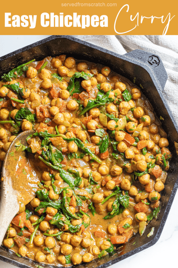 a cast iron of chickpea curry with spinach with a wooden spoon with Pinterest pin text.