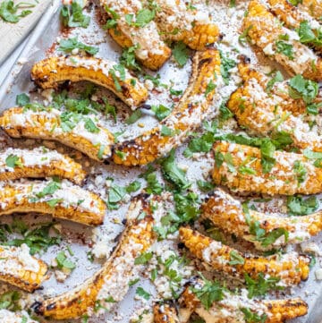 a tray of corn ribs with cheese and cilantro.