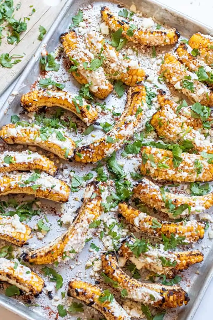 a tray of corn ribs with cheese and cilantro.