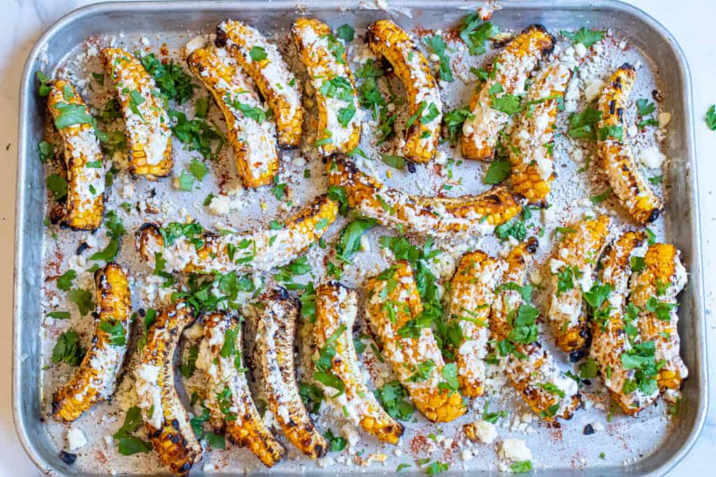 cooked Mexican corn ribs, coated with cheese and cilantro.