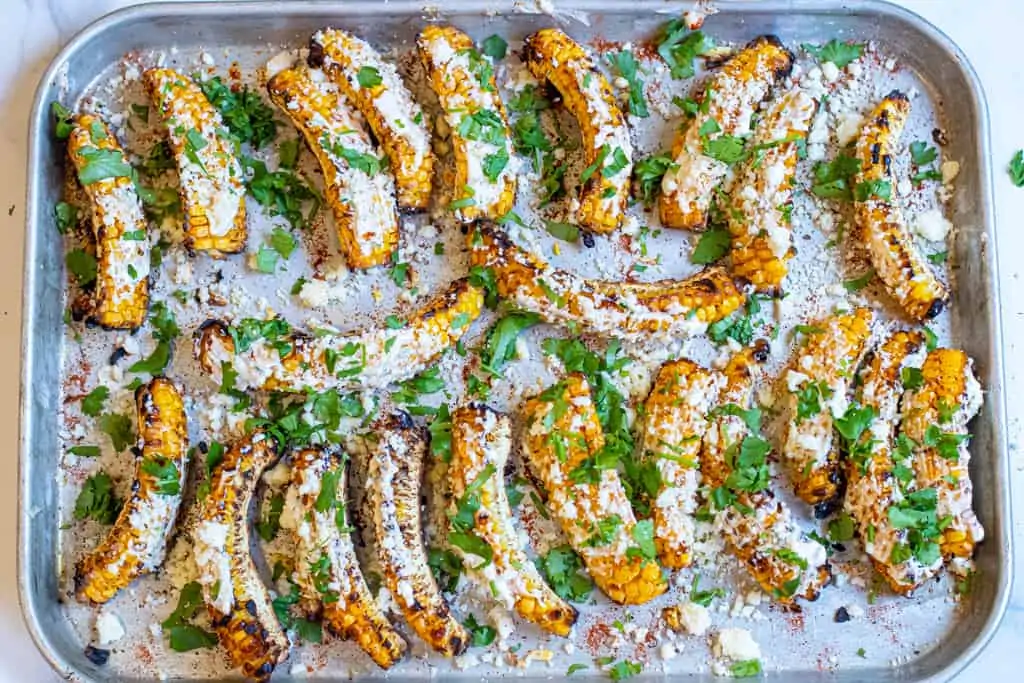 cooked Mexican corn ribs, coated with cheese and cilantro.