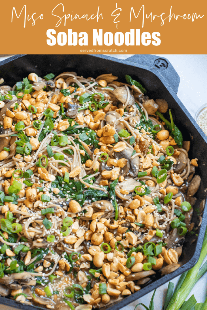 cast iron of noodles with spinach, mushrooms, topped with peanuts and scallions with Pinterest pin text.