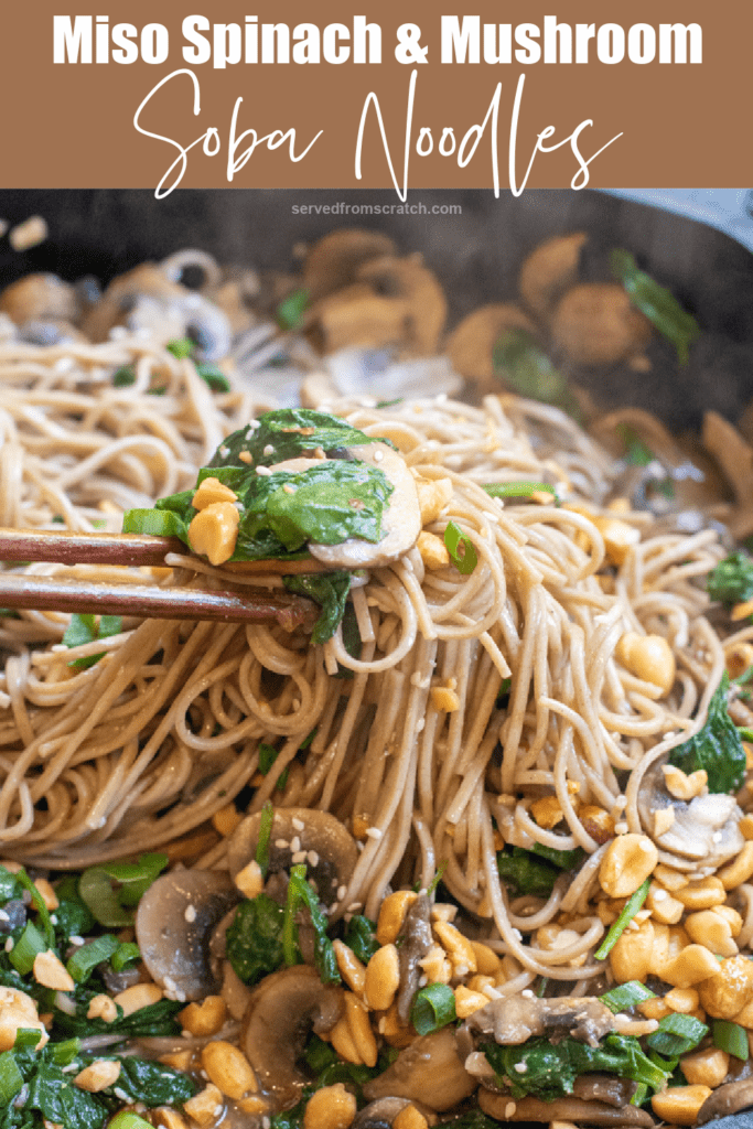 cast iron of noodles with spinach, mushrooms, topped with peanuts and scallions chopsticks holding up noodles with Pinterest pin text.