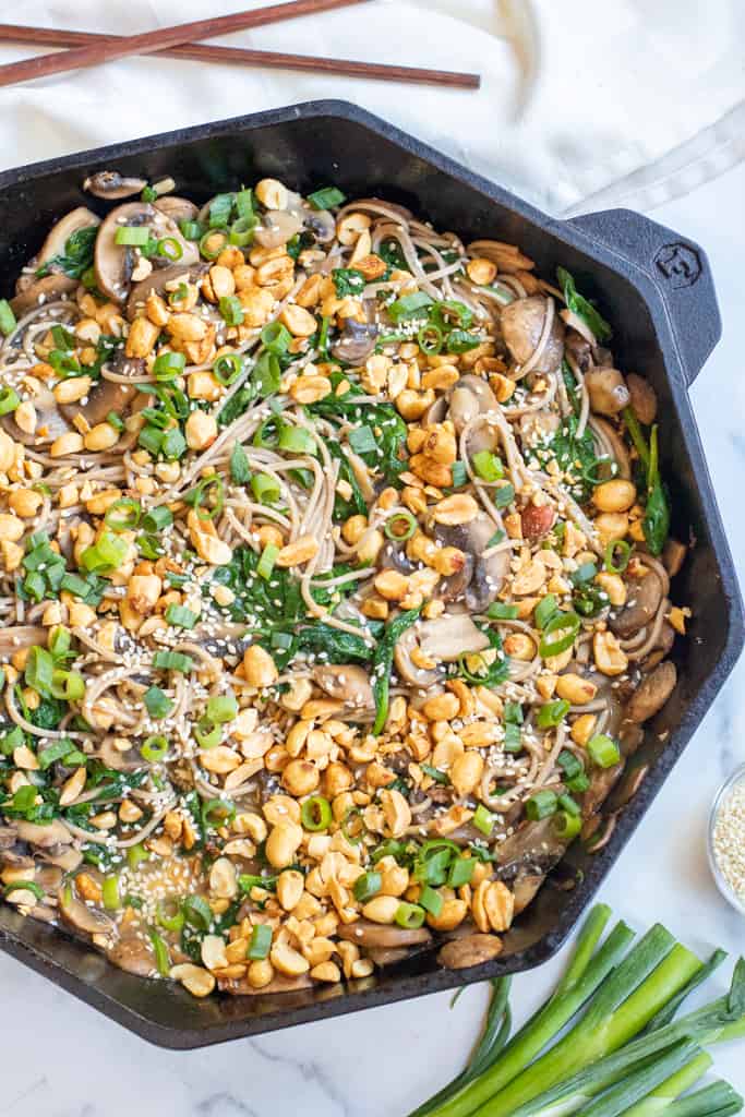 cast iron of noodles with spinach, mushrooms, topped with peanuts and scallions.