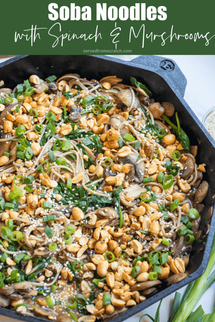 cast iron of noodles with spinach, mushrooms, topped with peanuts and scallions with Pinterest pin text.