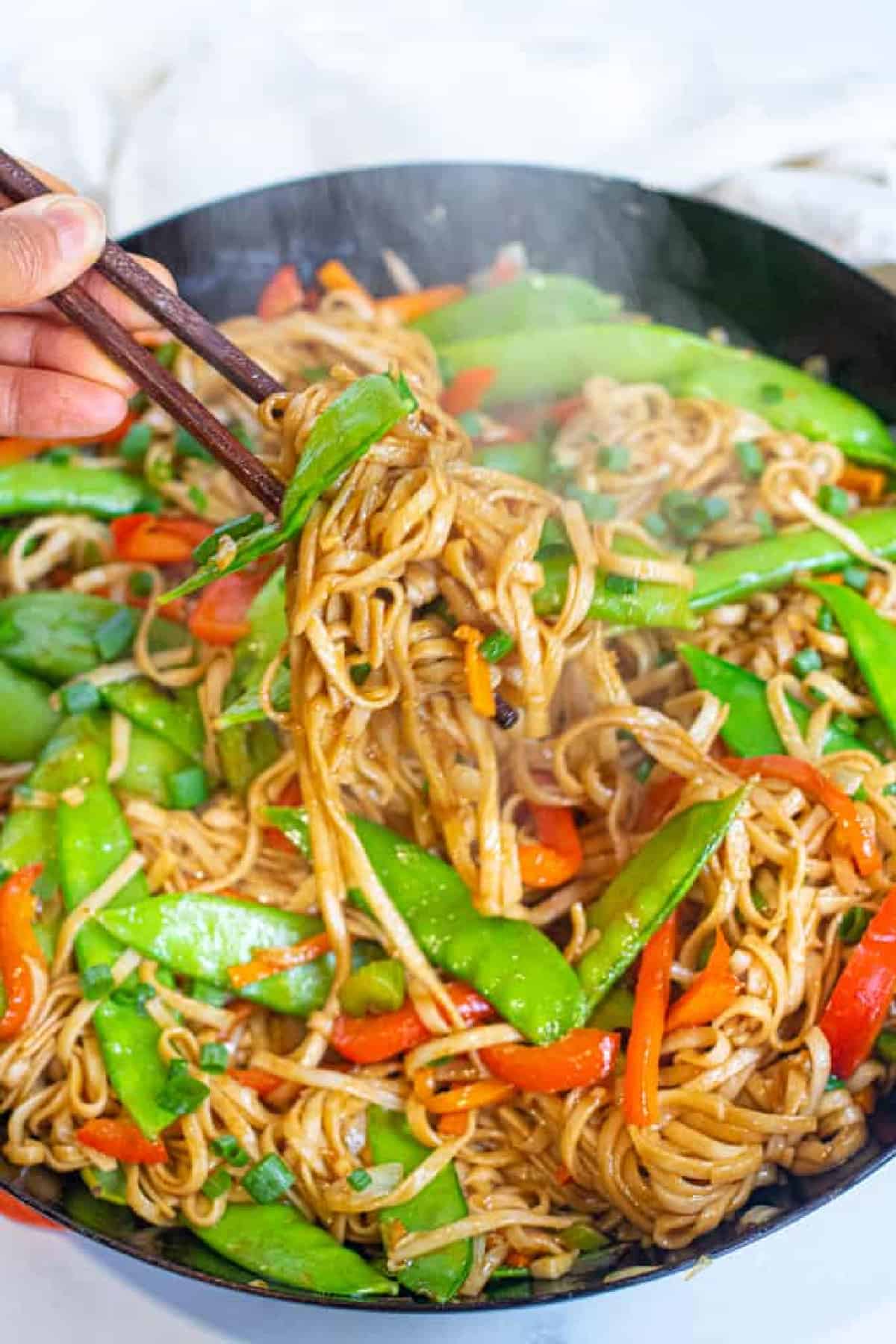 chopsticks holding up veggie noodles.