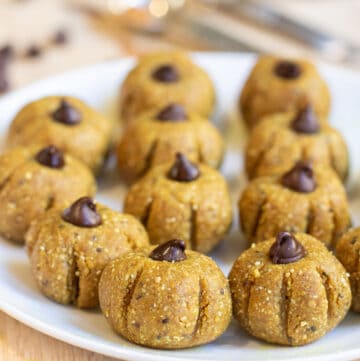 a plate of pumpkin shaped bliss balls.