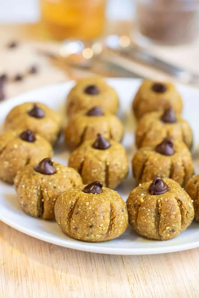 a plate of pumpkin shaped bliss balls.