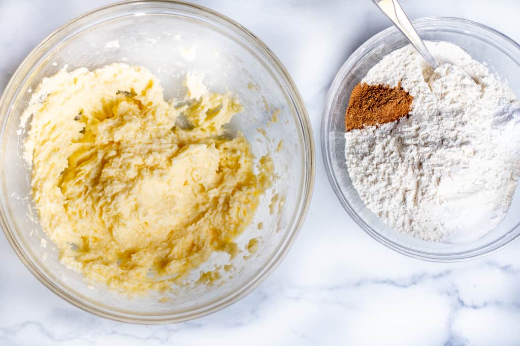 a bowl of creamed sugar and butter and eggs and a bowl of flour mixed.
