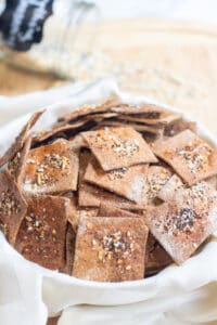 a bowl of crispy crackers with everything bagel toppings.