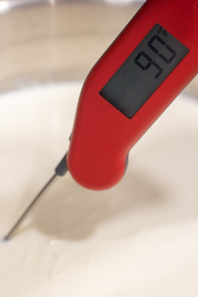 a thermometer reading 90 degrees in milk