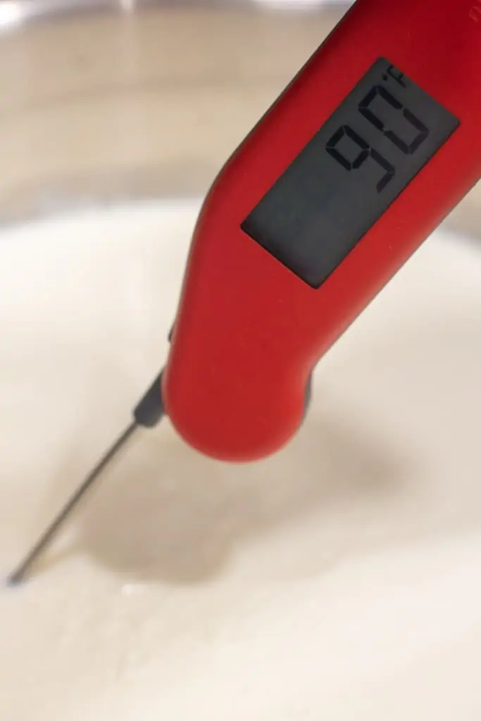 a thermometer reading 90 degrees in milk