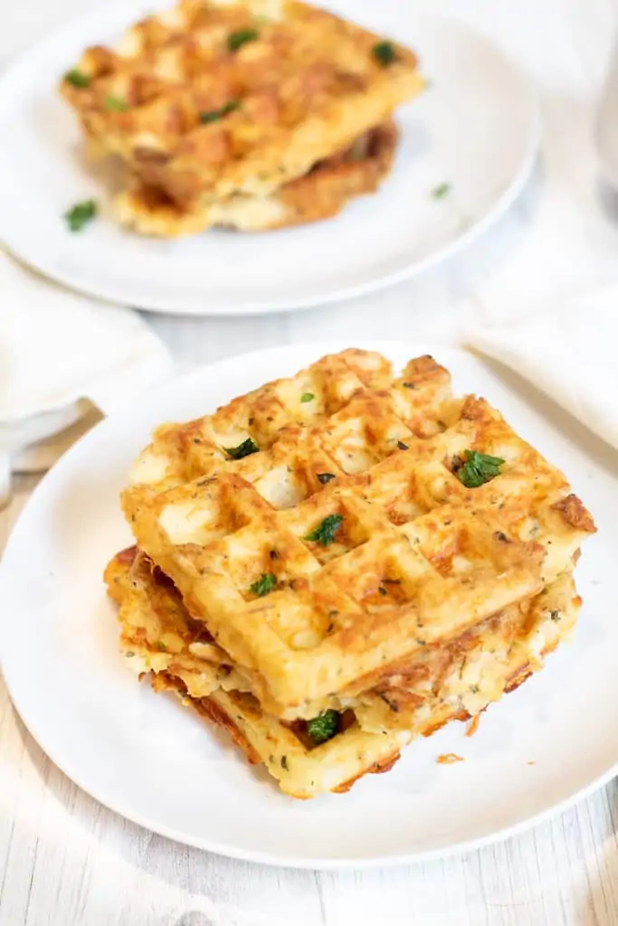 two plates of stacked potato waffles.