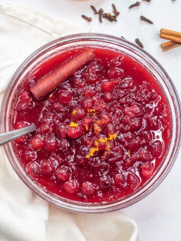 a bowl of homemade cranberry sauce with a spoon.