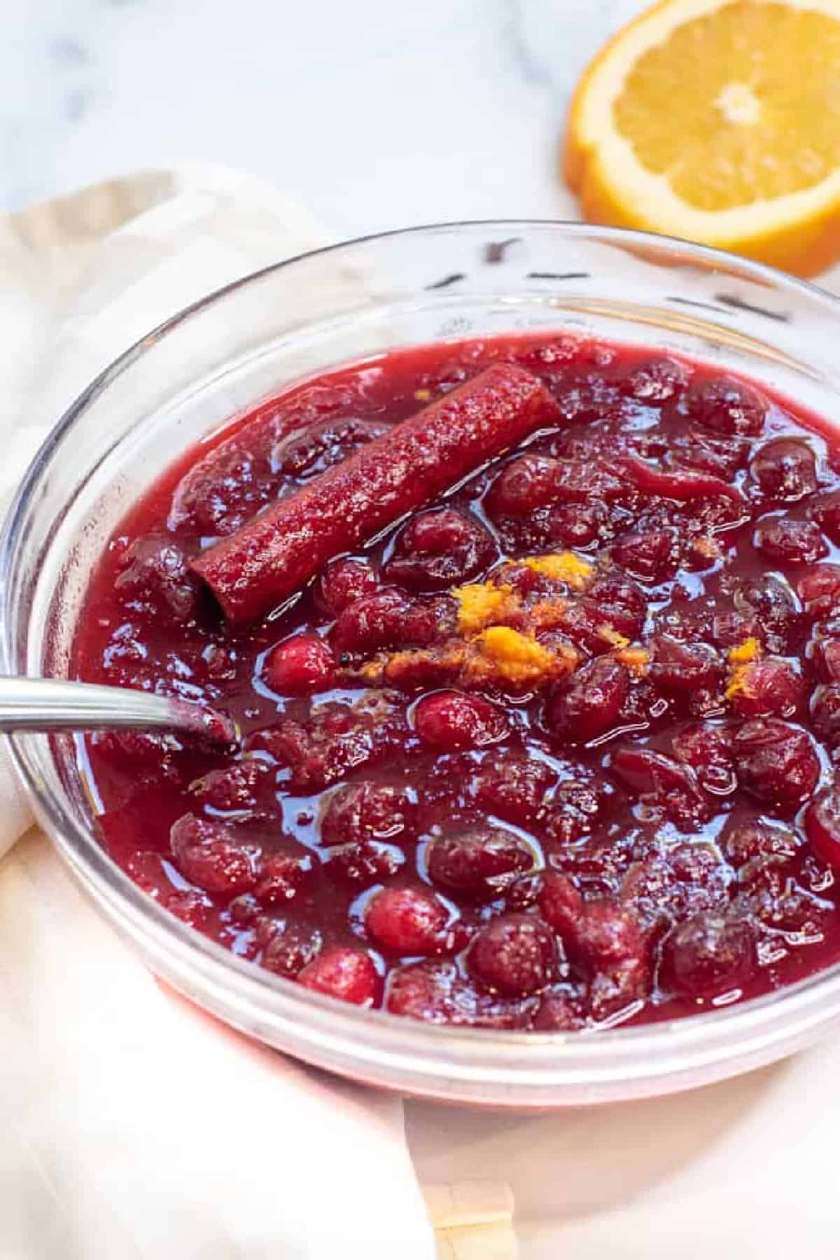 a bowl of homemade cranberry sauce with a spoon.