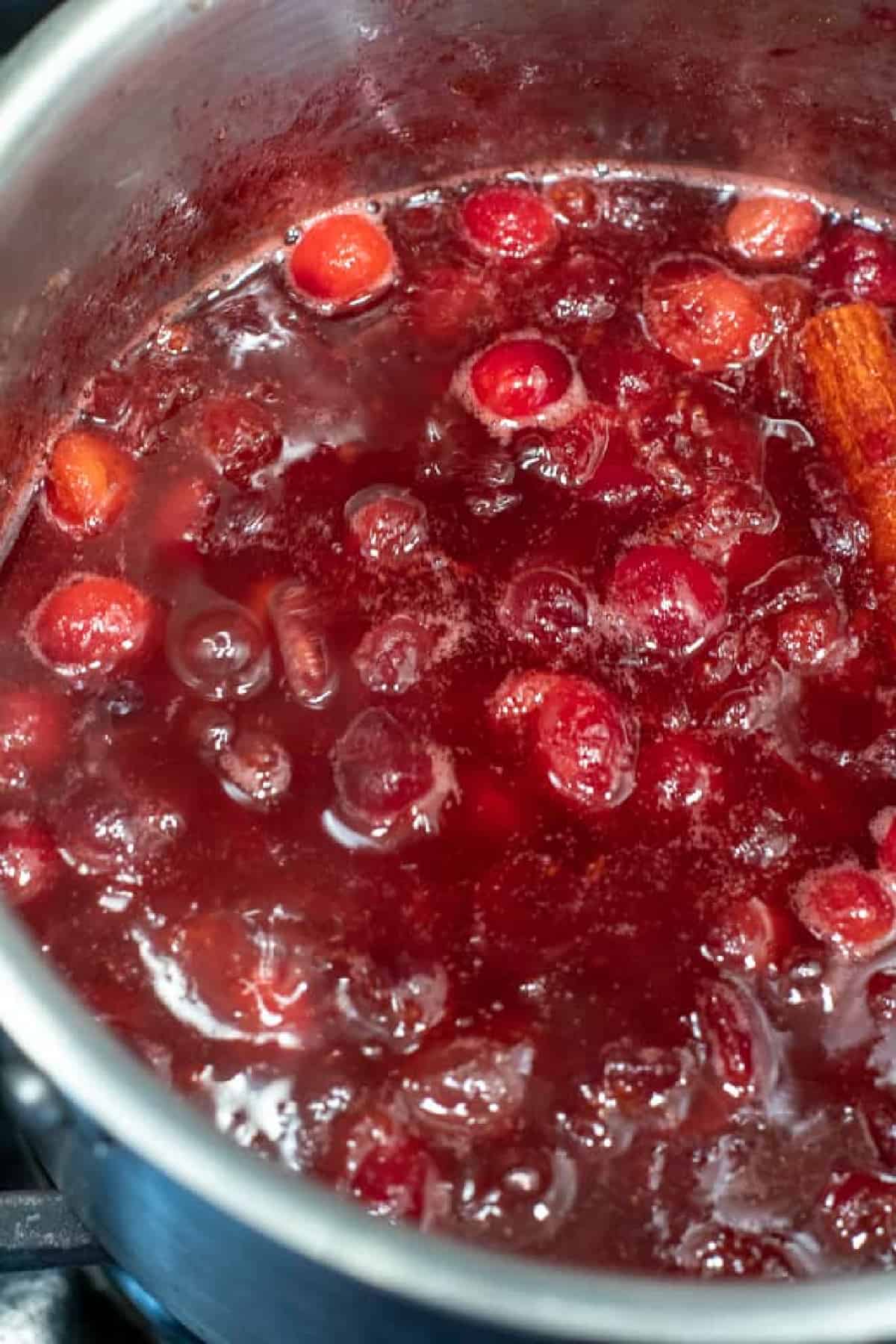 a saucepan with simmered cranberries.