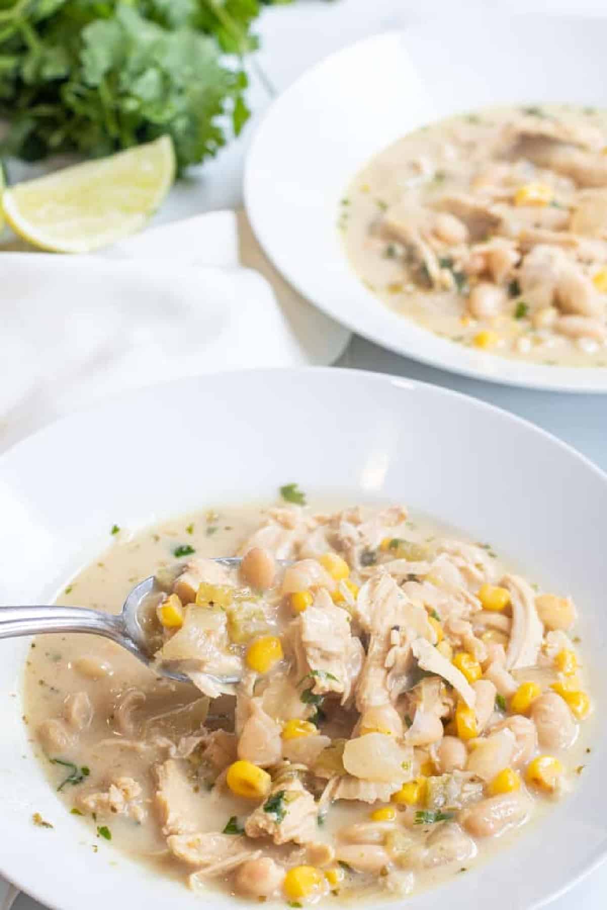 a spoonful of white chili over a bowl.