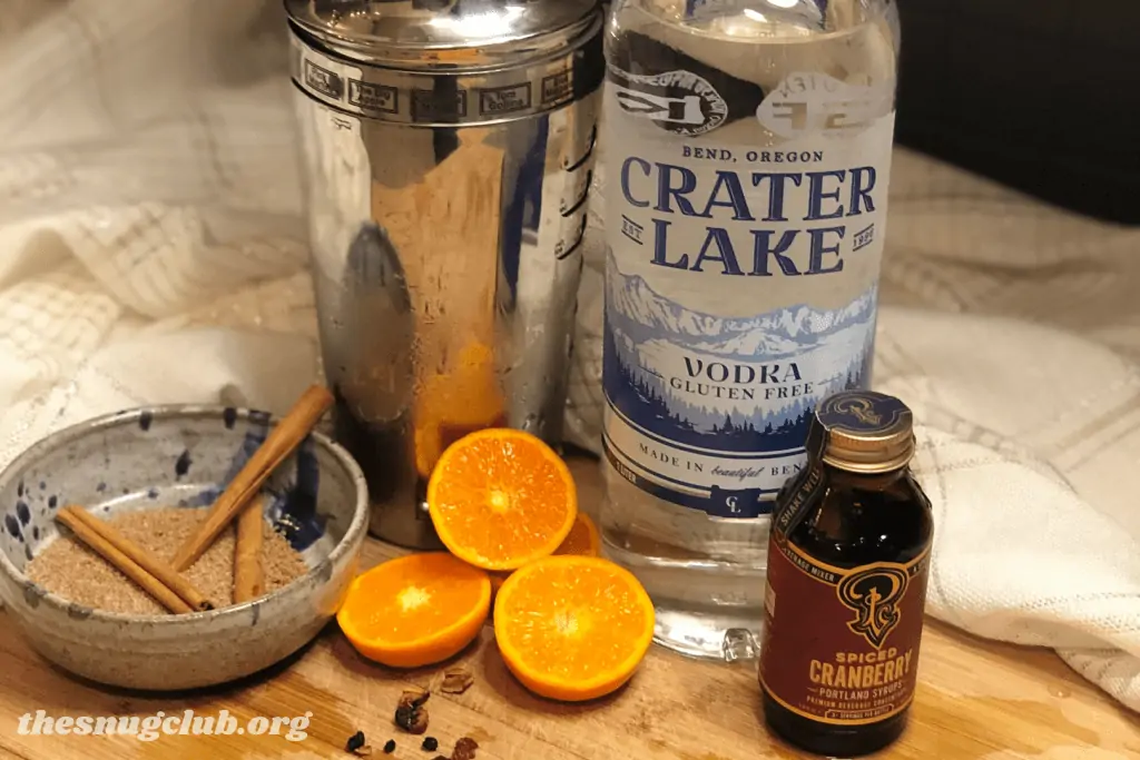 vodka, a shaker, sliced mandarins, portland syrup, and cinnamon.