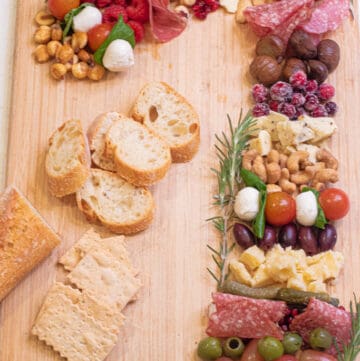 a Charcuterie Board in the shape of a candy cane on a cutting board.