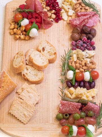 a Charcuterie Board in the shape of a candy cane on a cutting board.