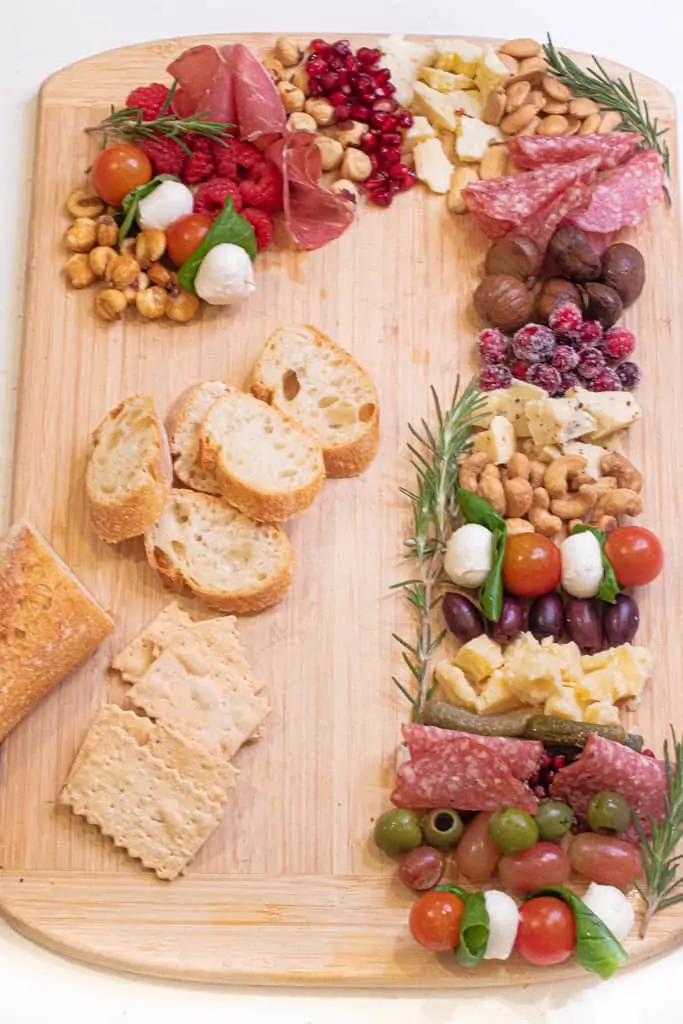 a Charcuterie Board in the shape of a candy cane on a cutting board.