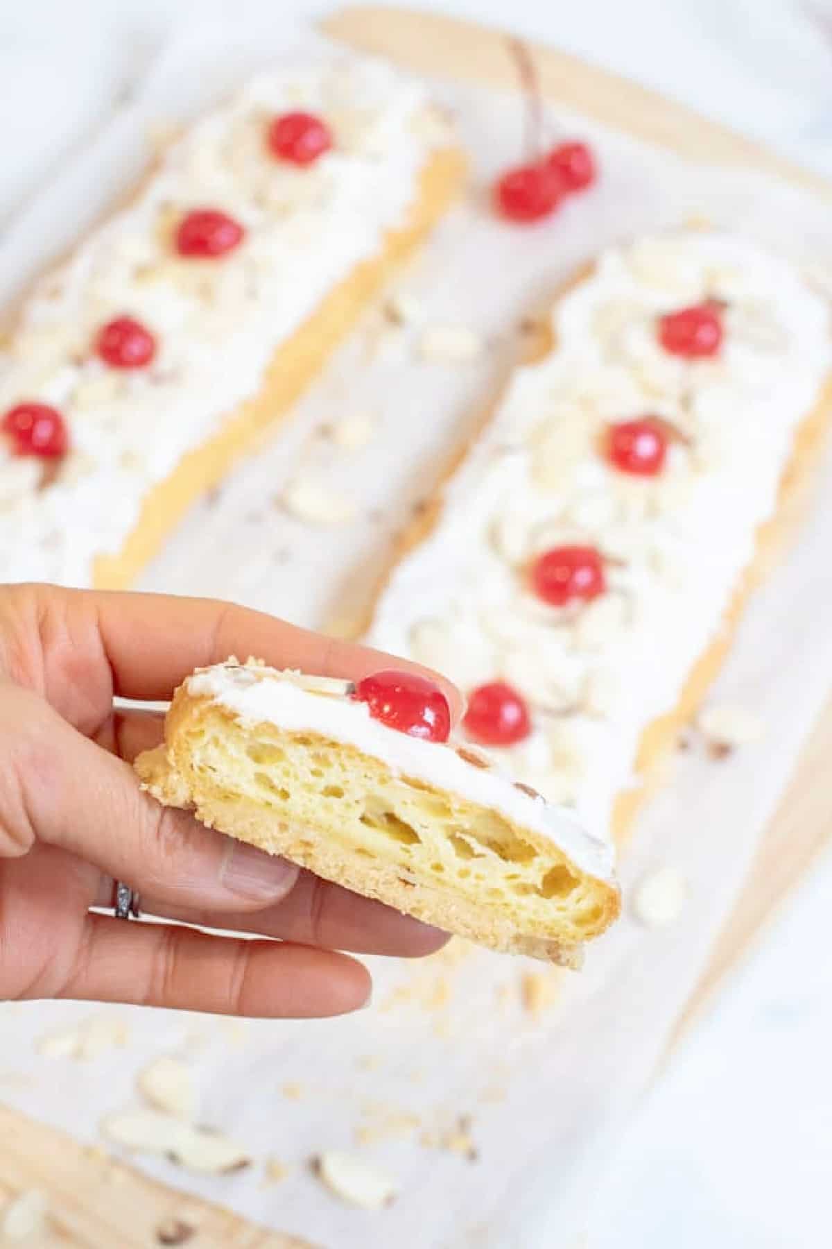 a hand holding a slice of danish puff pastry.