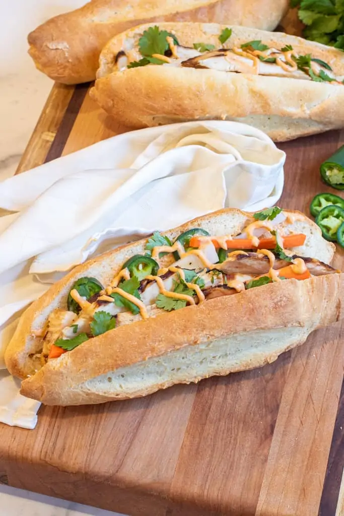 two banh mis on a cutting board. 