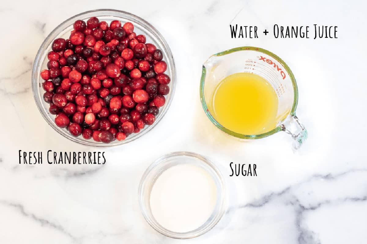 a bowl of cranberries and a bowl of sugar and orange juice.