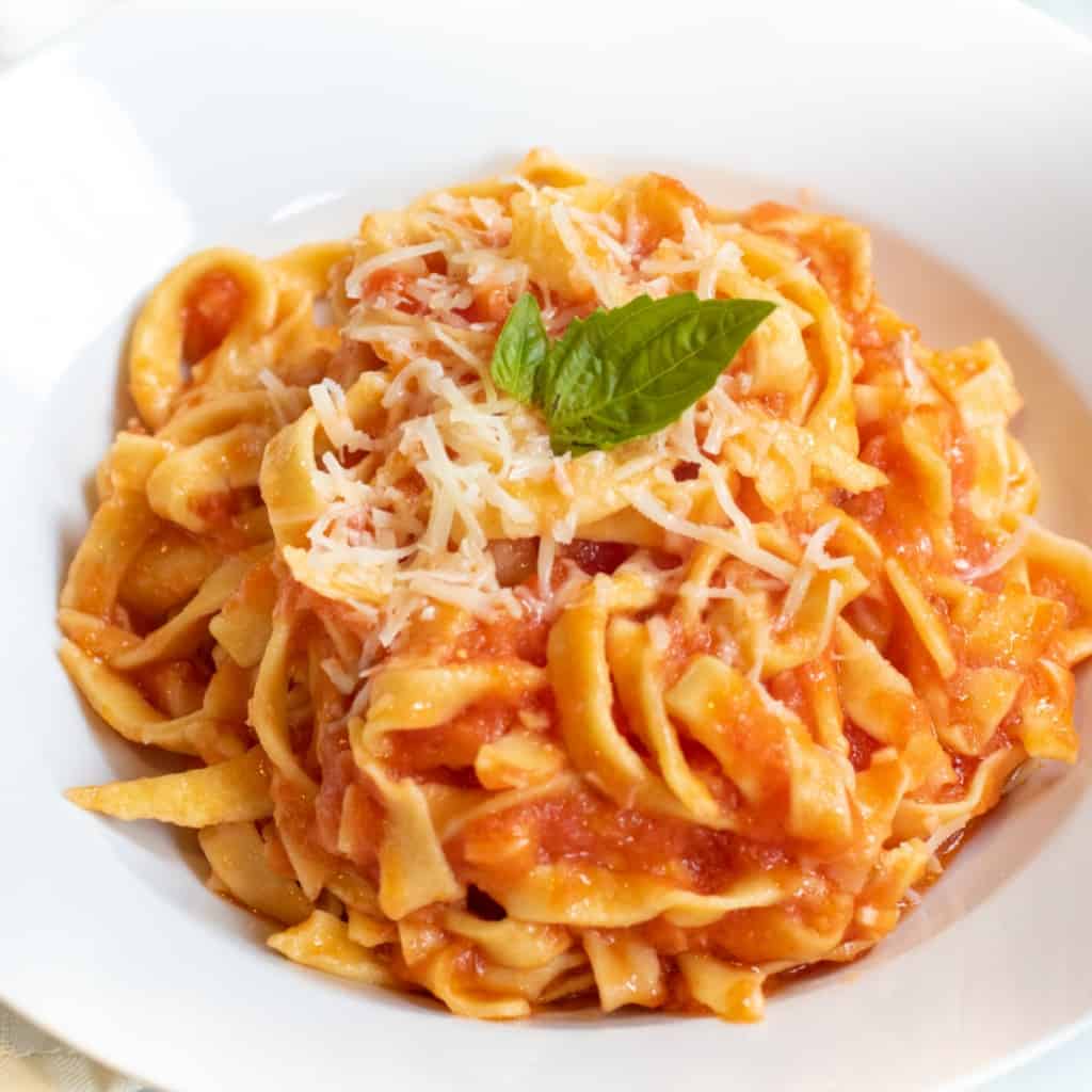 a plate of fresh pasta and marinara sauce.