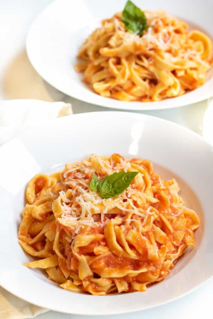 a plate of fresh pasta and marinara sauce.