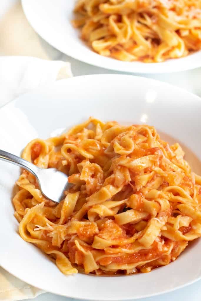 a plate of fresh pasta and marinara with a fork.