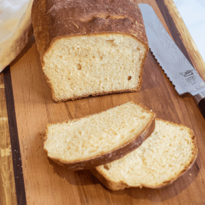 a loaf and sliced bread on a board.