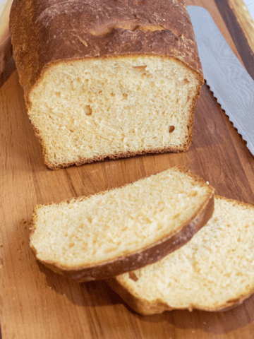 a loaf and sliced bread on a board.