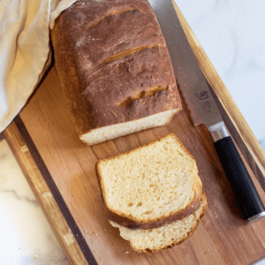 a loaf and sliced bread on a board.