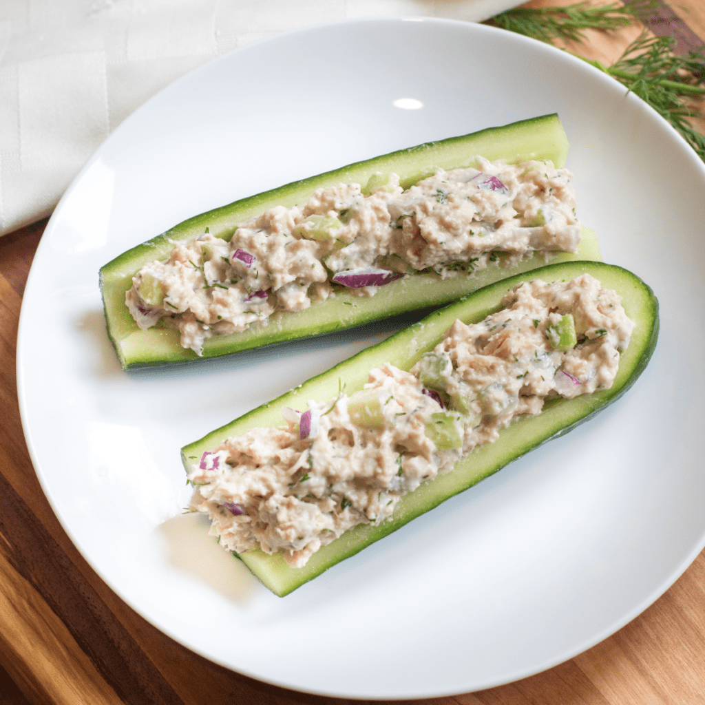 a plate with cucumber boats and tuna salad.