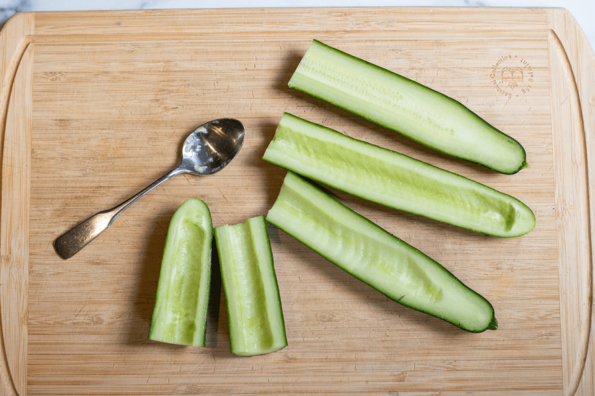 cucumbers with the seeds hallowed out on a cutting board.