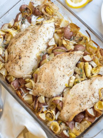 a pan of baked chicken with potatoes, leeks.