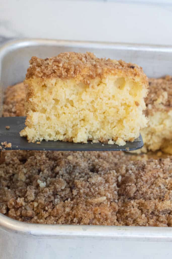 a piece of coffee cake coming out of a tray.