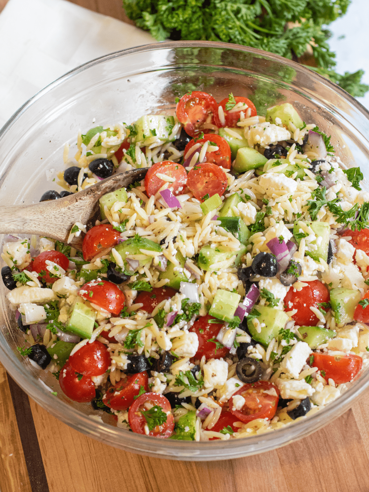 a large bowl of olives, cucumbers, tomatoes, orzo, feta.