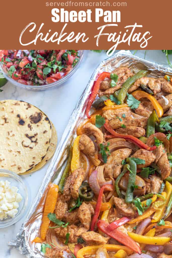 a sheet pan of chicken fajitas, corn tortillas, pico, and cheese with Pinterest pin text.